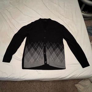 A black and grey plaid, J. Ferrar cardigan sweater. Size Large.